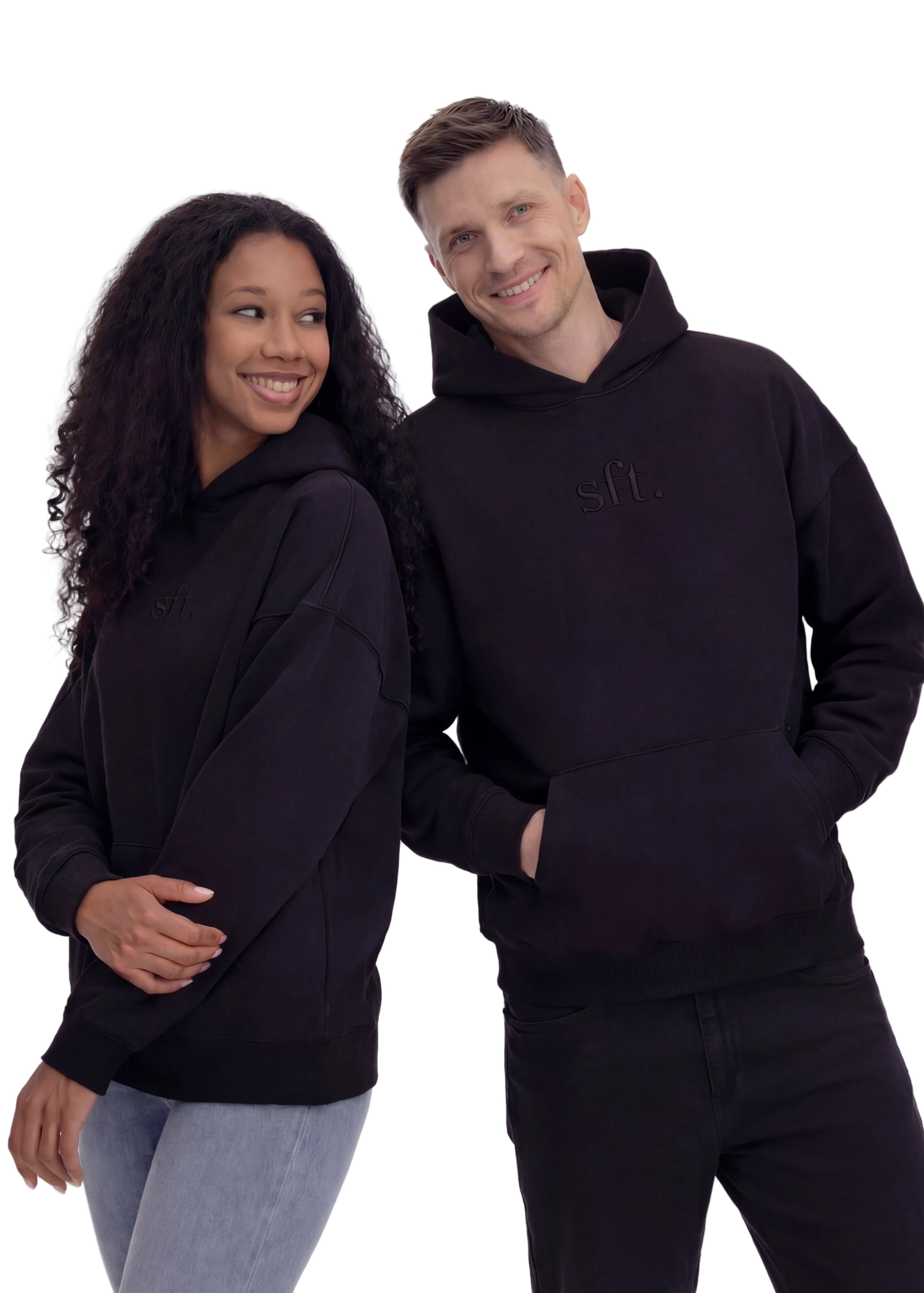 Two people wearing black hoodies on a white background