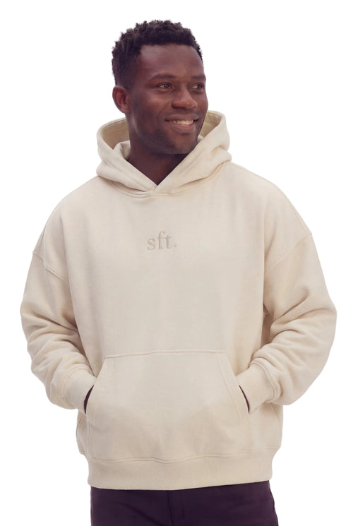 Man wearing a beige hoodie with 'sft' logo on a white background