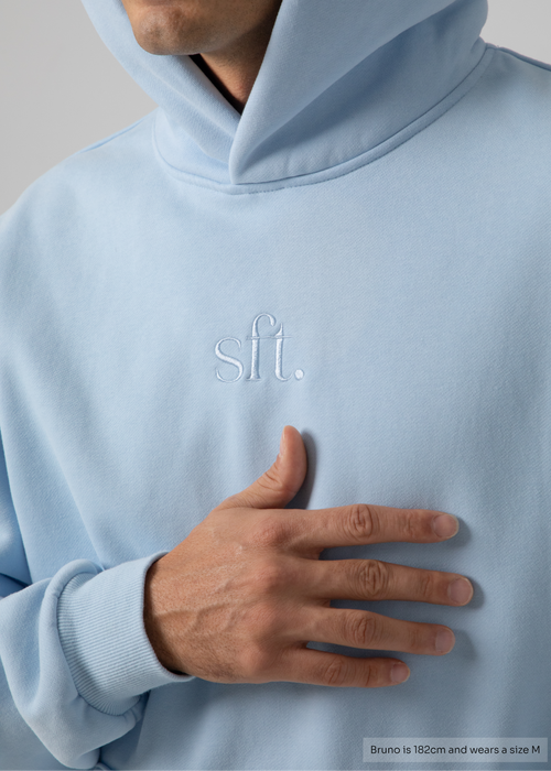 Light blue hoodie with 'sft' logo on chest, worn by a person.