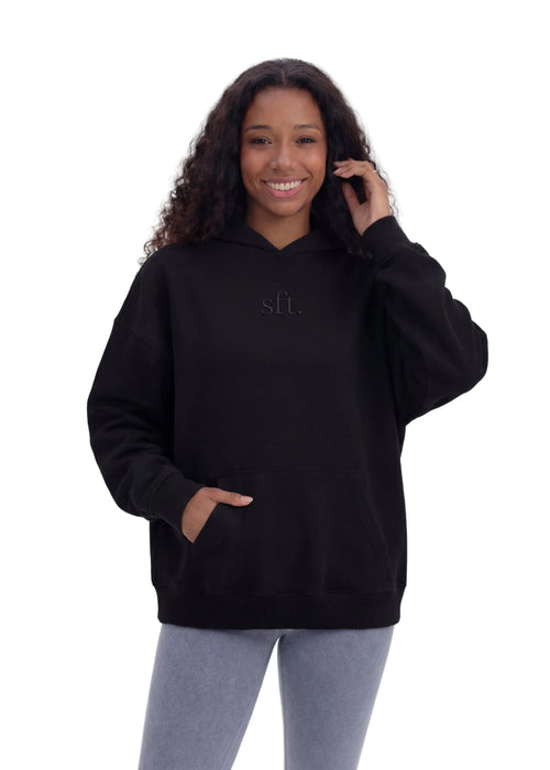 Person wearing a black hoodie with 'slf.' text on a white background